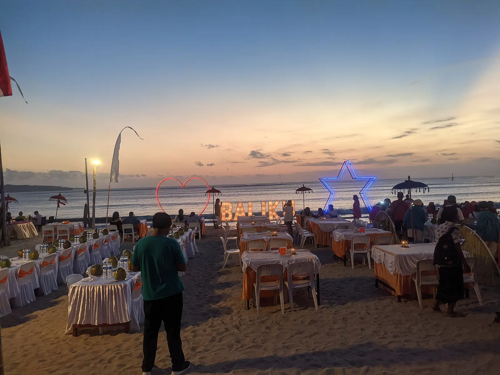 Tables set out on the sand for dinner at Jimbaran Bay as the sun goes down